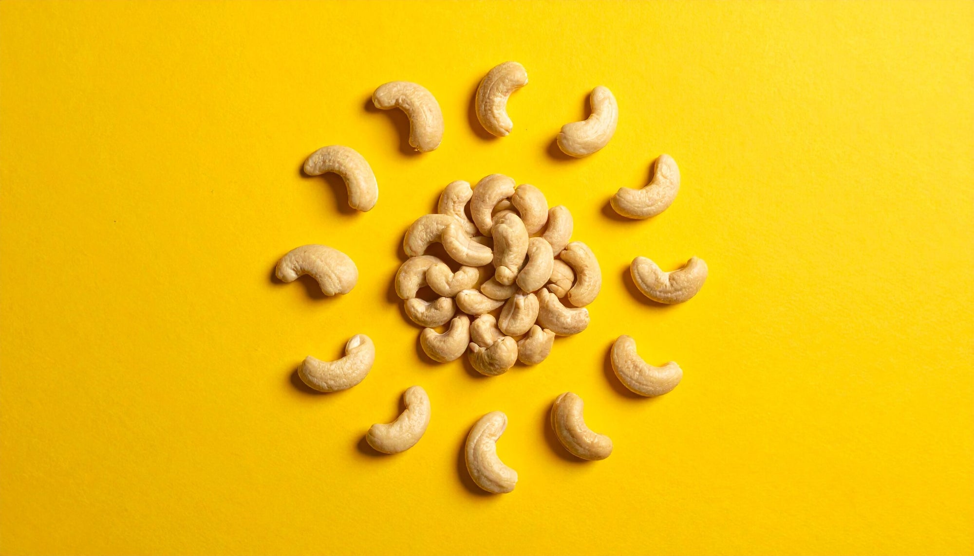 Activated organic Cashew butter – nuts in a circular pattern on a yellow background