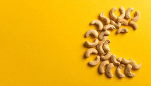activated Organic Cashew nuts arranged in a pattern on a yellow background
